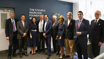 A group of people stand in front of the Stavros Niarchos Foundation Wing at Chatham House